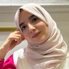 Meryem Ghatrif, her head resting on her hand, smiling softly.